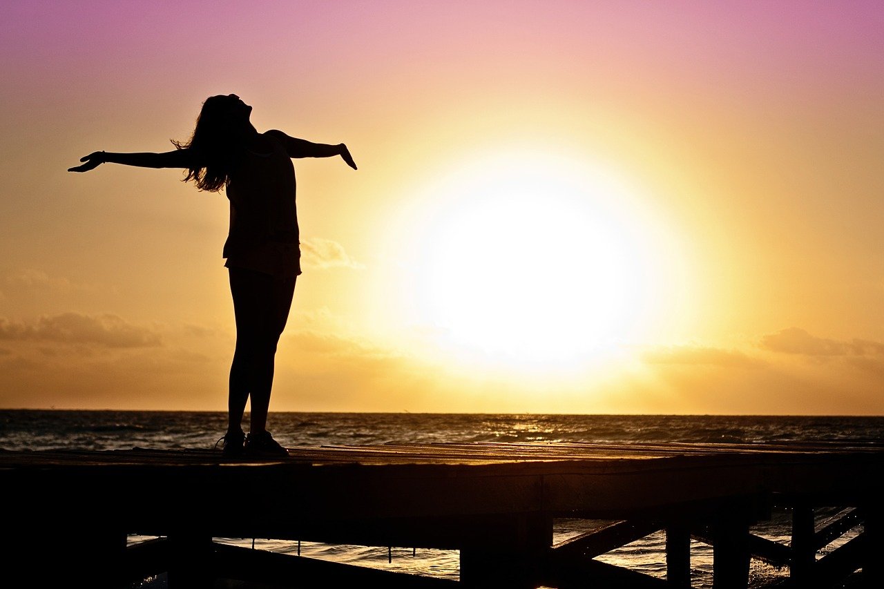 Woman shining her heart towards the sun